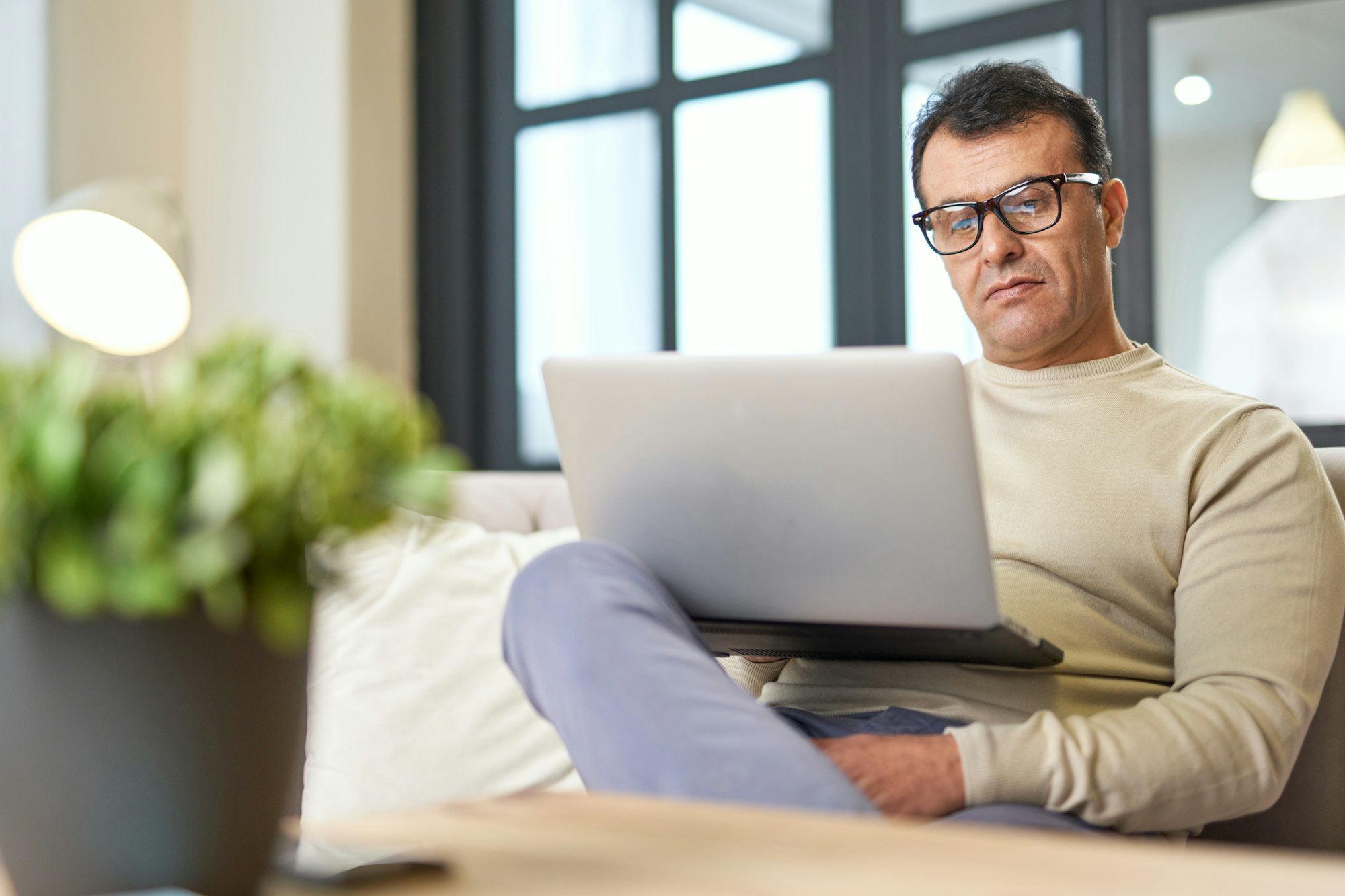 Freelance worker. Portrait of latin middle aged business man with eyeglasses working at home on some
